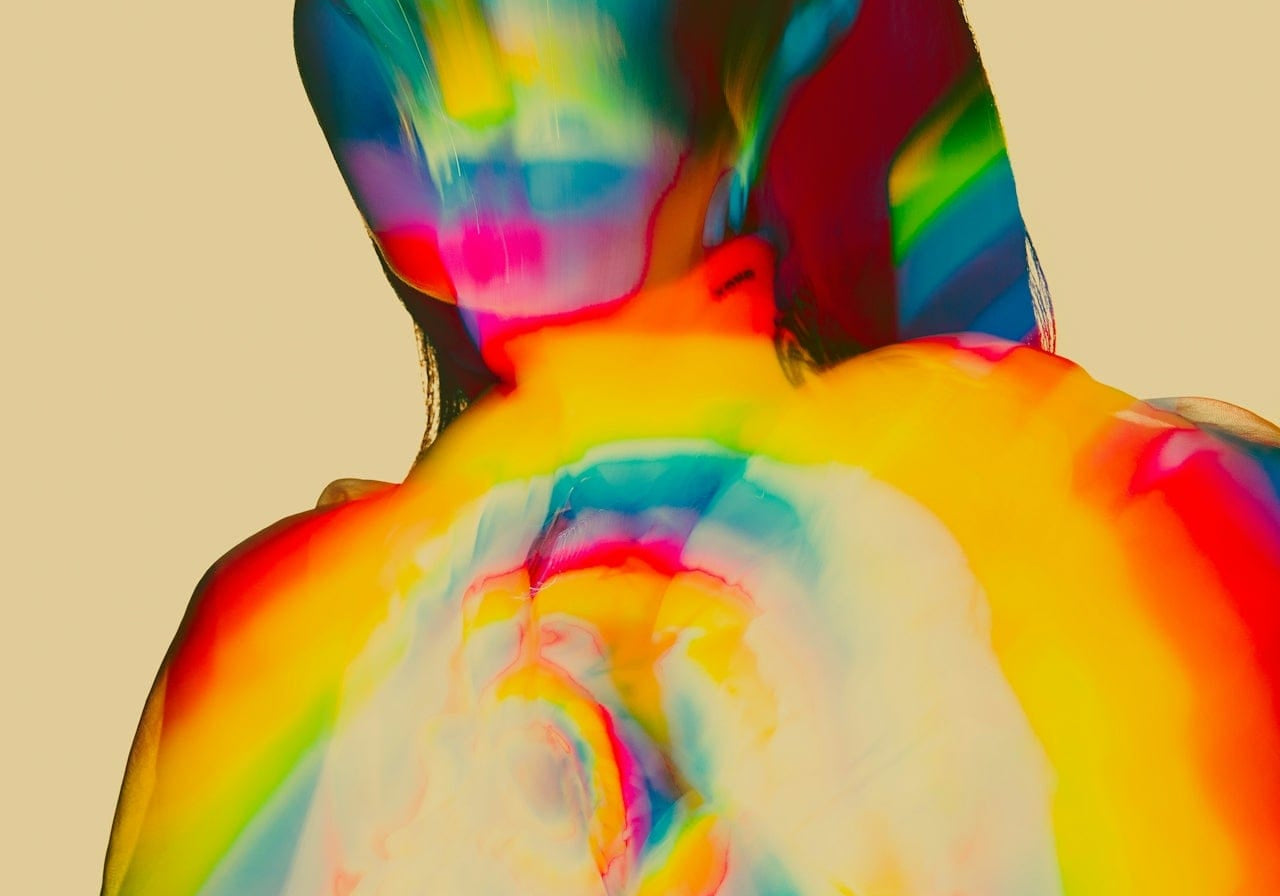 Rainbow-hued double exposure of a woman from behind, cover image for nervous system dysregulation