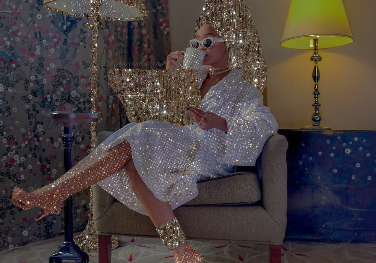 Woman in a white robe surrounded by gold sequins sipping tea, cover image for the new currency of leadership
