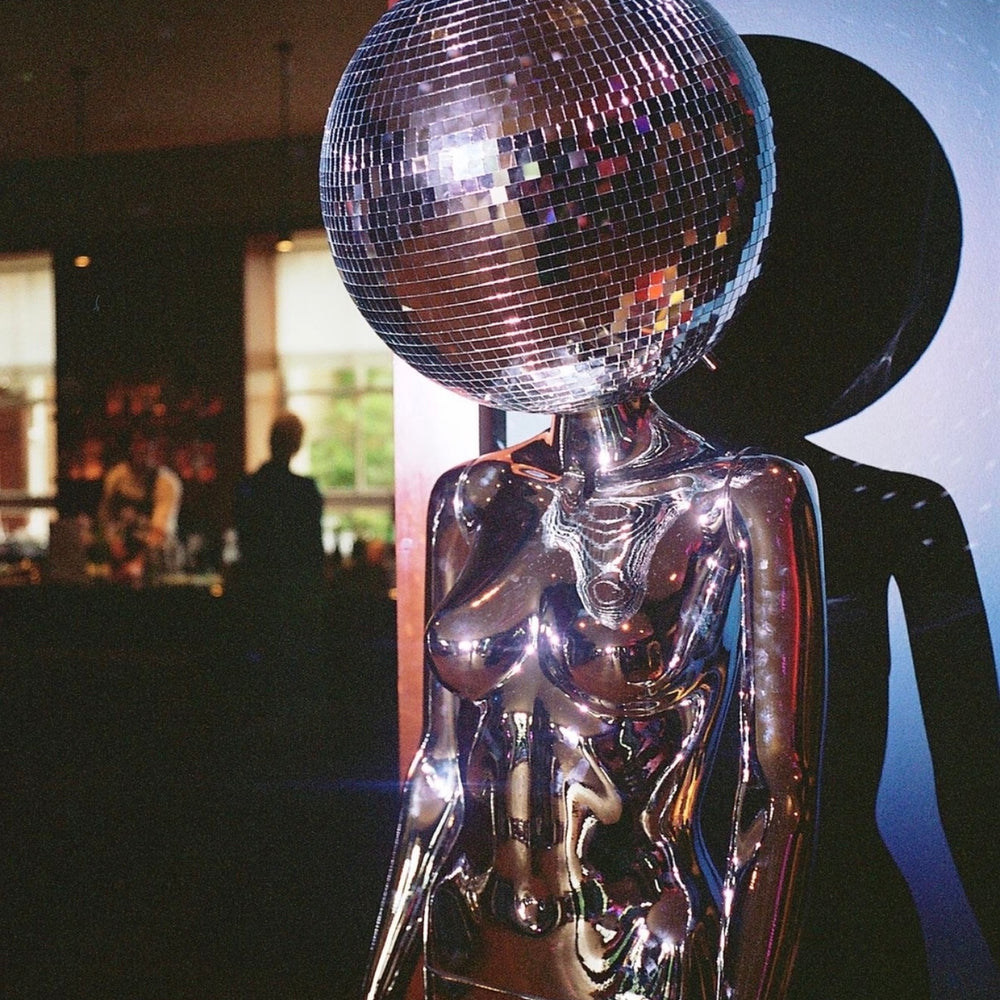 Lady with a disco ball head and silver costume