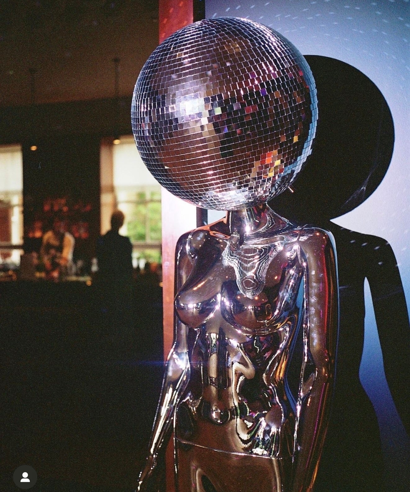Lady with a disco ball head and silver costume