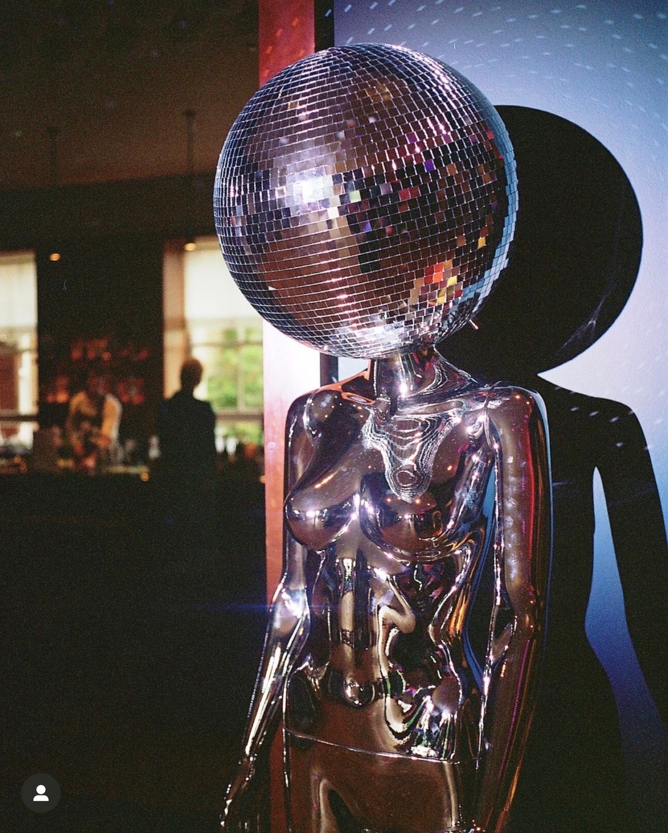 Lady with a disco ball head and silver costume