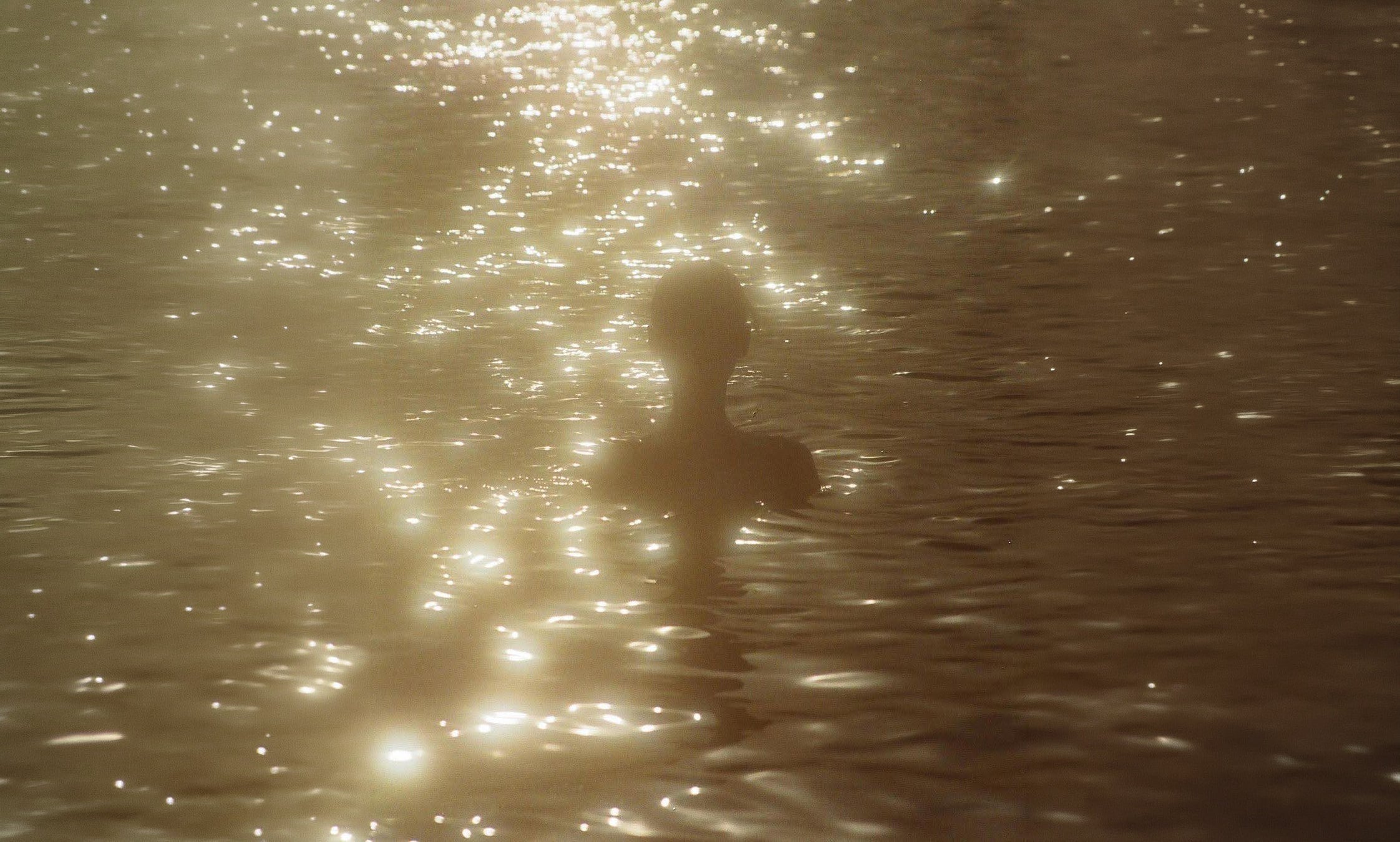 Swimmer in golden sunlit water, cover image for the quarter life crisis article